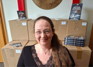 Die Autorin Stephanie K. Braun vor einem Stapel Bücher von Matteos Zeitreisen